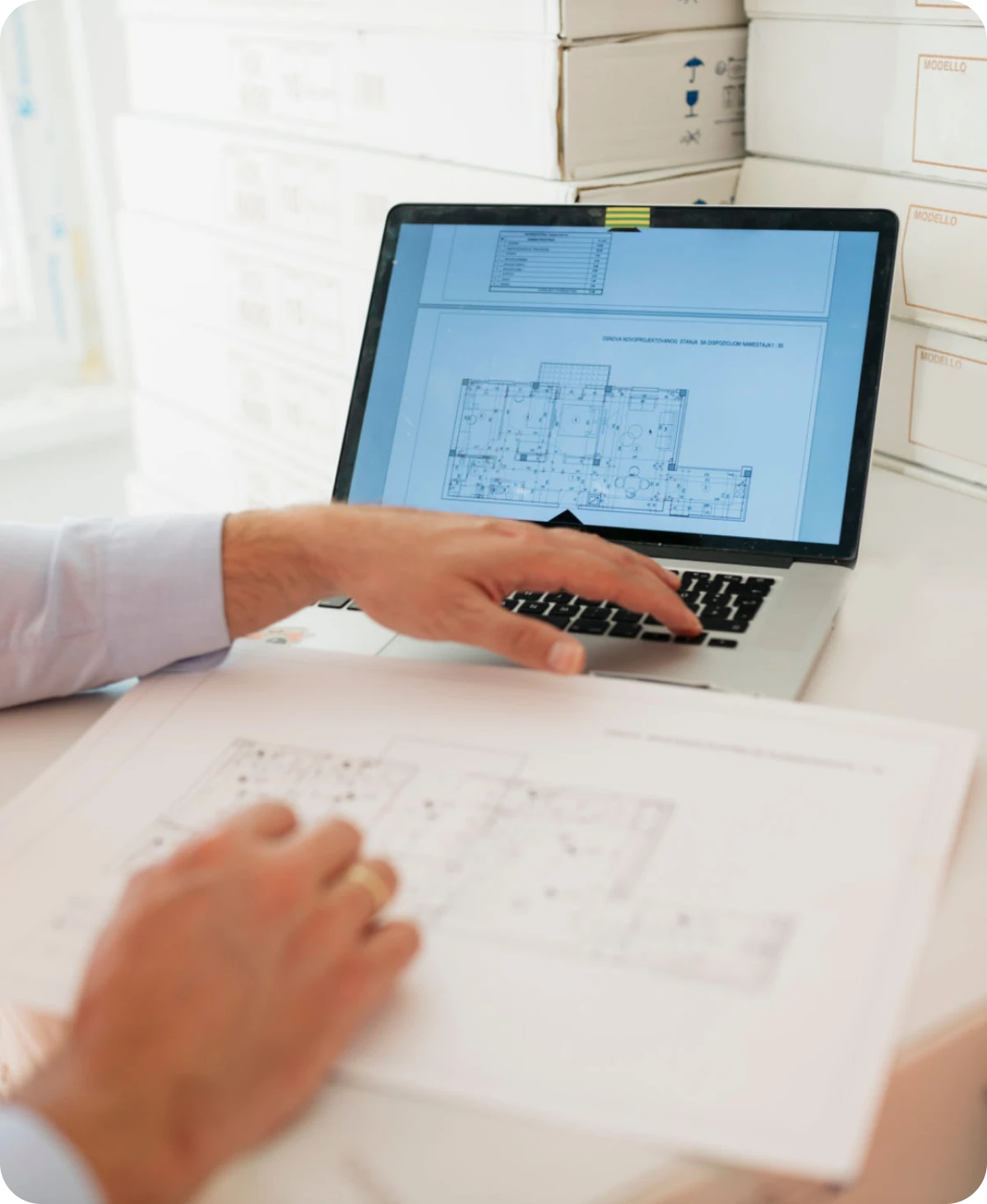 Architect reviewing building plans on laptop